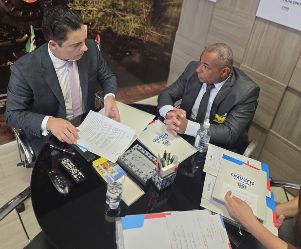 sentados ao redor de uma mesa, estão o deputado Márcio Alvino (à esquerda da imagem) e o vereador Baiano da Saúde (à direita).