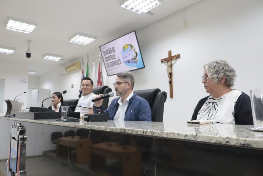 Sentados na Mesa Diretiva da Câmara estão, da esquerda para a direita, a diretora Gláucia Paulino, o vereador Marcel da ONG, o então secretário Diego Ferreira (ao microfone) e a diretora Priscila Arap, durante audiência do setor de Controle de Zoonoses realizada no ano passado.