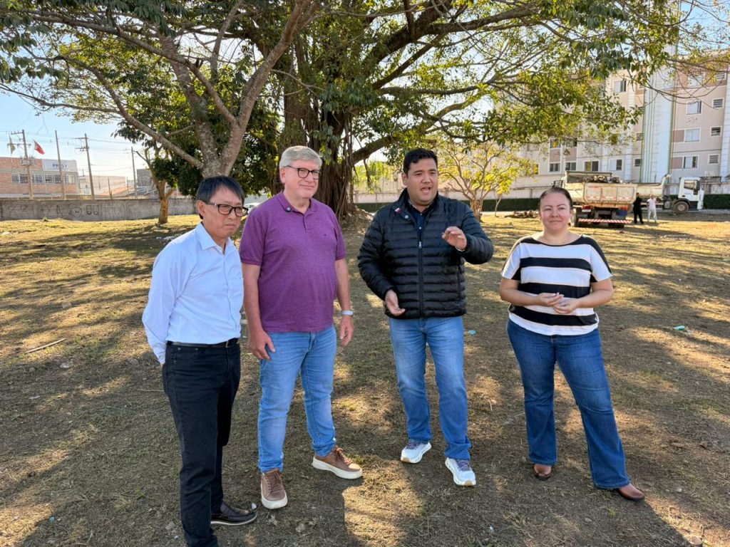 de pé em um terreno, sob a sombra de uma árvore, estão lado a lado, da esquerda para a direita, o vereador Artur Takayama, o secretário Samuel de Oliveira, o prefeito Pedro Ishi e a secretária Renata Priscila.