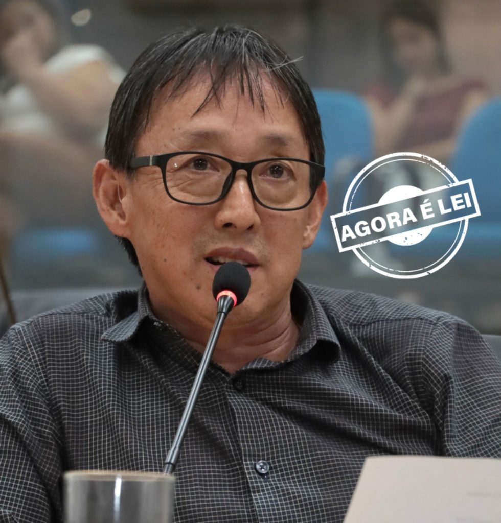 vereador Artur Takayama fala ao microfone no Plenário da Câmara. Ele usa uma camisa social xadrez.
