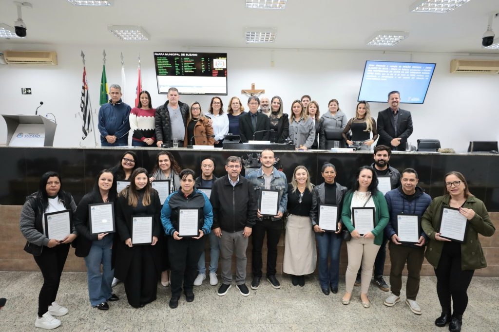 De pé, no Plenário da Câmara, equipe da USF Vereador Marsal Lopes Rosa segura moção de aplauso que recebeu do vereador Denis (ao centro).