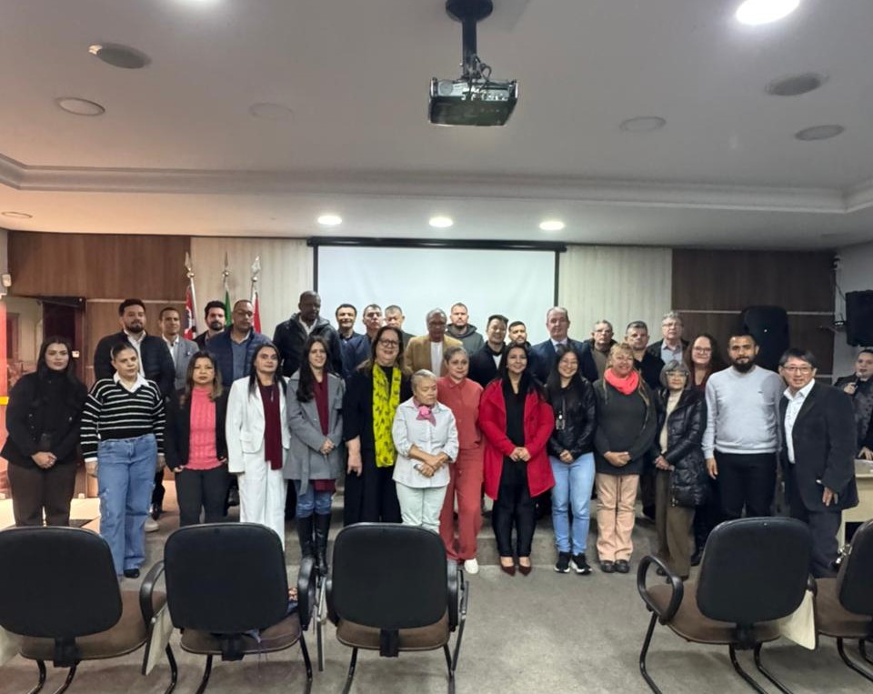 Participantes de posse do Comtur posam para foto, tendo ao lado direito os vereadores Artur Takayama (de blazer preto e camisa branca) e Dirceu filho do Carlão da Limpeza (de pulover cinza).