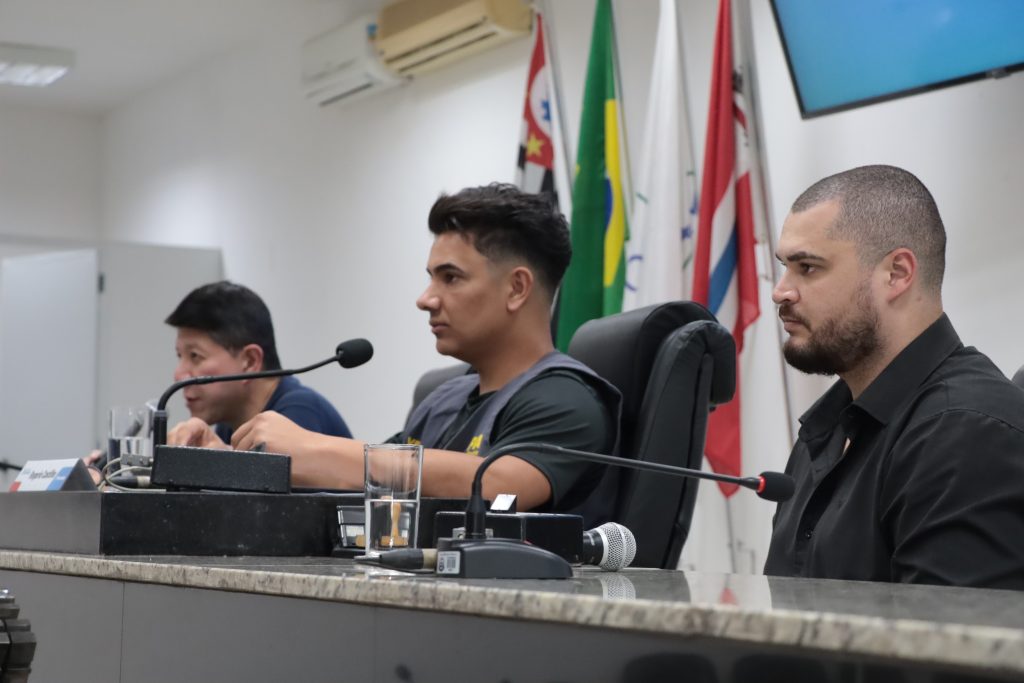 sentados na Mesa Diretiva da Câmara, da esquerda para a direita, estão o secretário William Harada, o vereador Rogerio Castilho e o chefe de gabinete Felipe Luis de Oliveira.