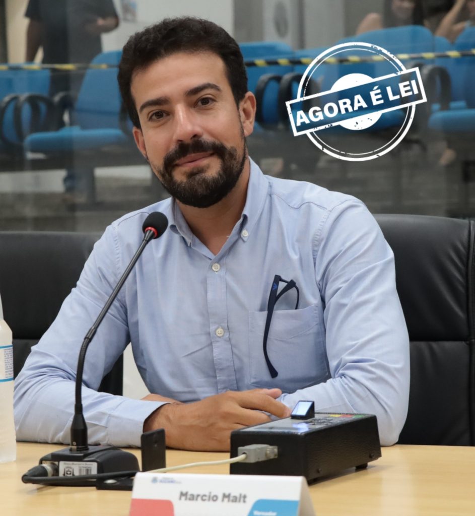 vereador Marcio Malt sentado atras de sua mesa no Plenário. Ele usa camisa social azul.