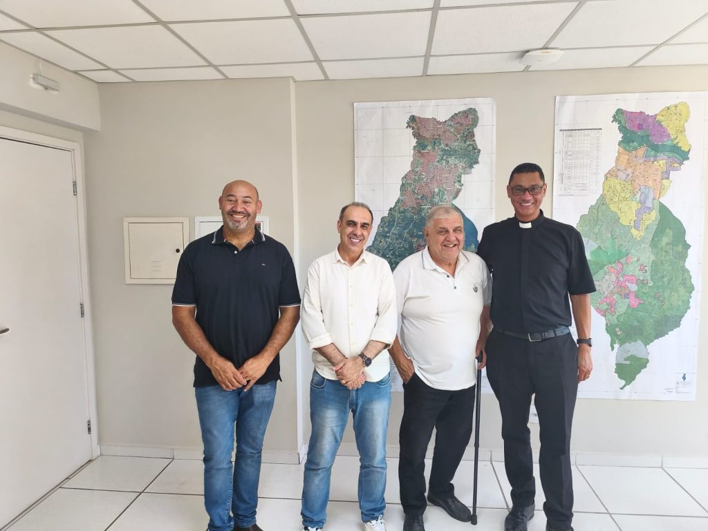 da esquerda para a direita, posam para foto, sorrindo, o vereador João Sabugo, o secretário Elvis Vieira, o agente de pastoral tio Toninho e o padre Domingos de Jesus.